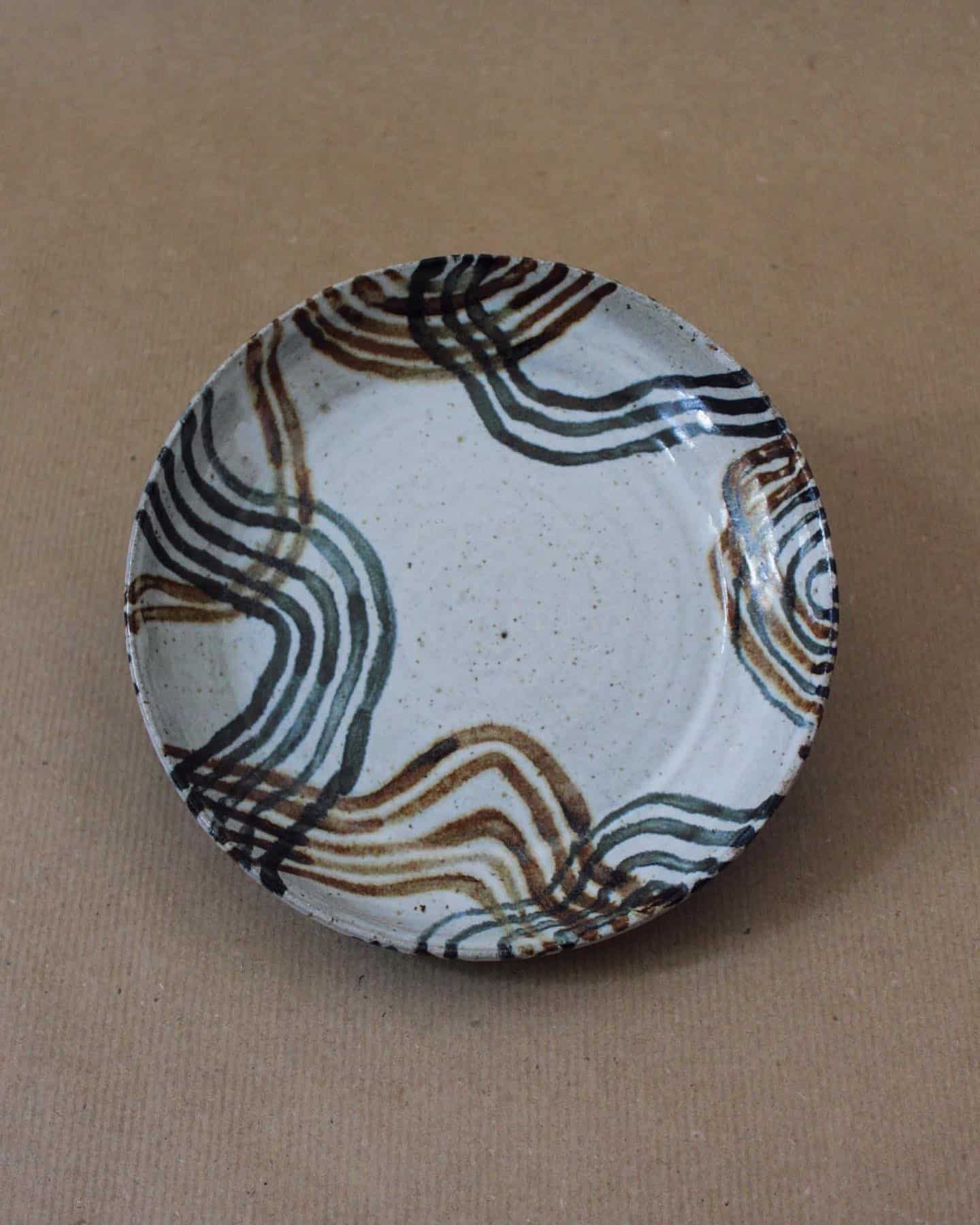 thrown ceramic plate with oxide brushstroke line patterns